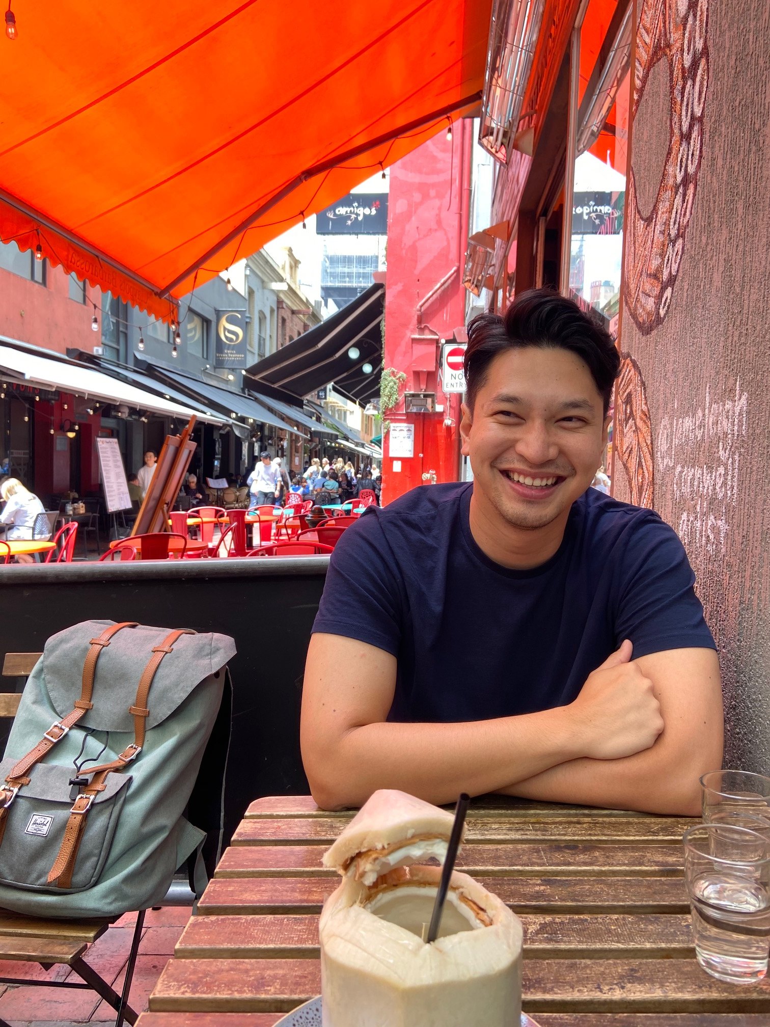 Raymond Tuason smiling at an outdoor cafe table